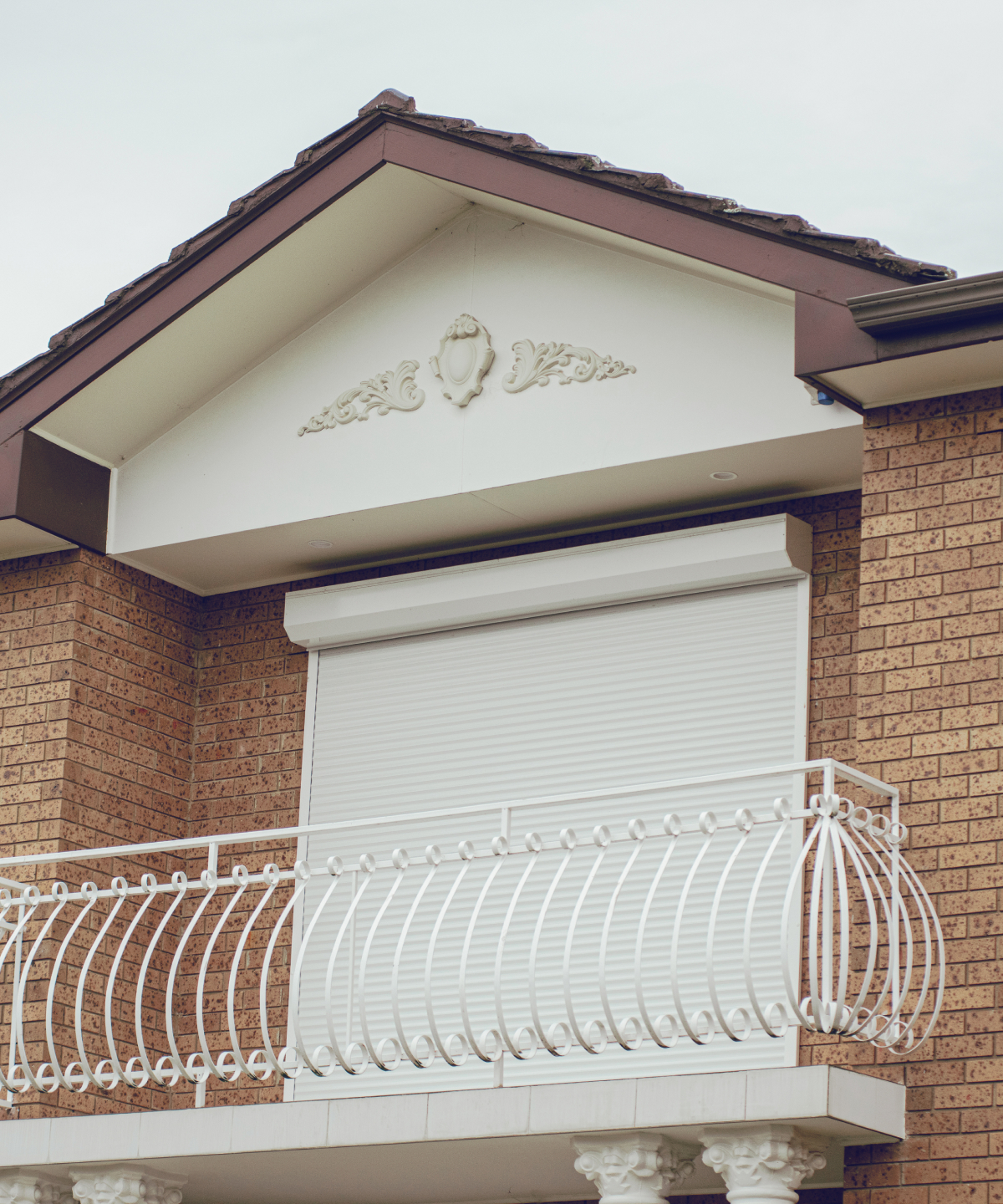 Upstairs window and balcony with a white roller shutter installed by HK Roller Shutters Melbourne