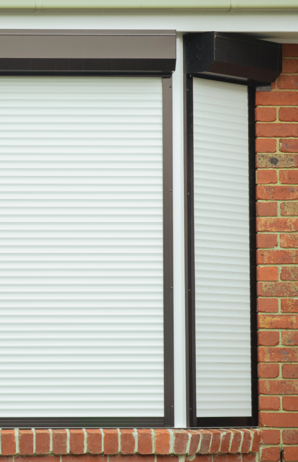 Bay window in brick house with stylish shutters installed by HK Roller Shutters Melbourne